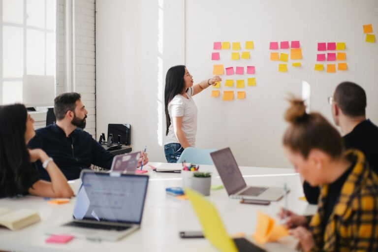 Business strategy team mapping out automated AI workflow pipelines on office whiteboard